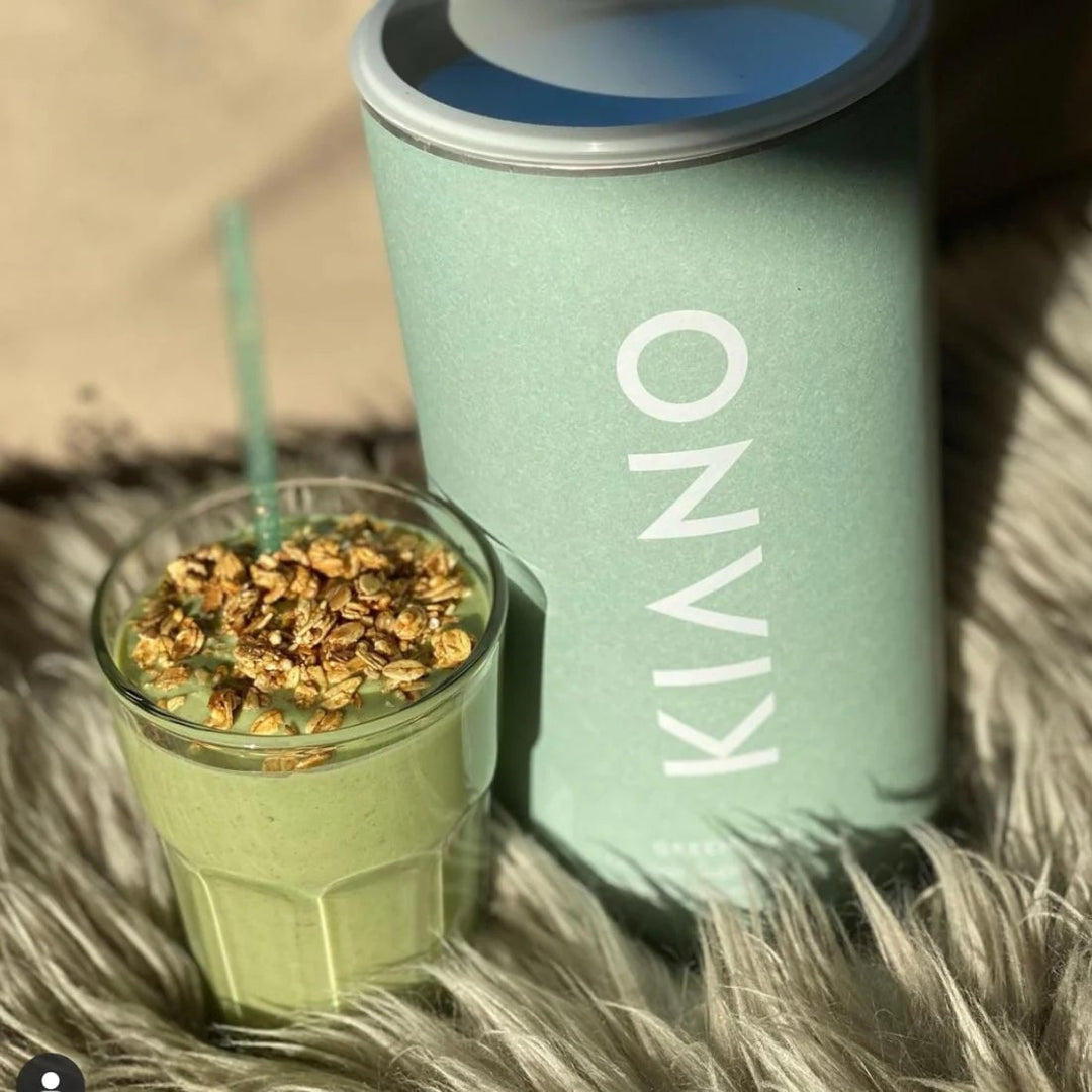KIANO Green Boost tin and a glass of green drink decorated with granola - serving suggestion