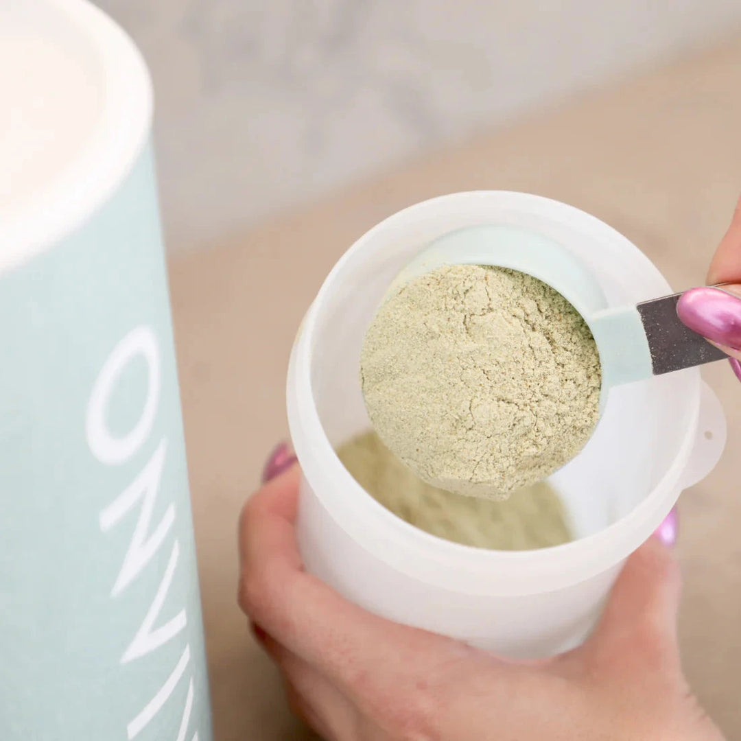 Hand holds a can in which a spoonful of Kiano Green Fuel is filled North Glow