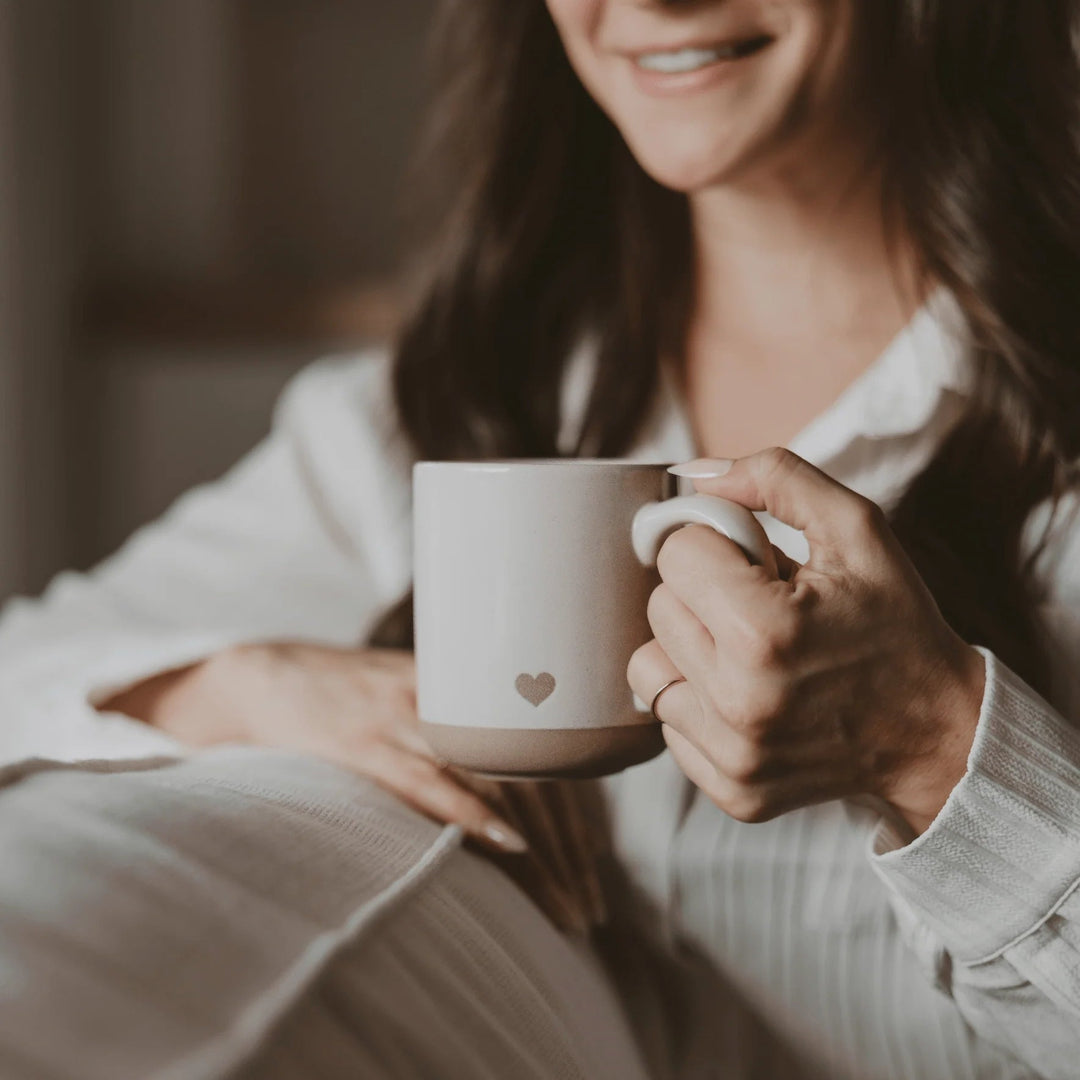 Herz Kaffeetasse aus cremefarbenem Steingut, in einer Frau gehalten North Glow