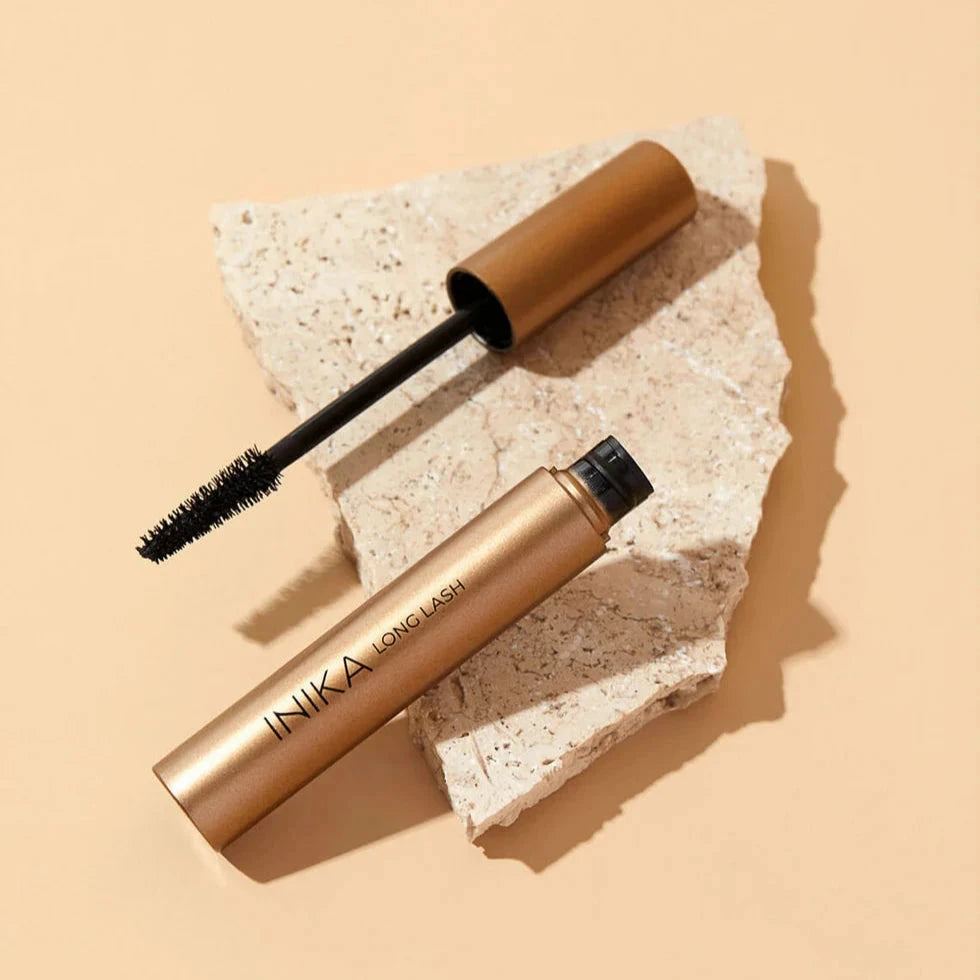 INIKA Long Lash Mascara opened, lying on a stone.