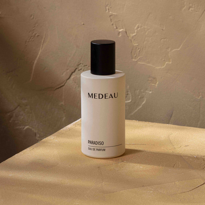 Medeau Paradiso perfume bottle stands on a stone slab