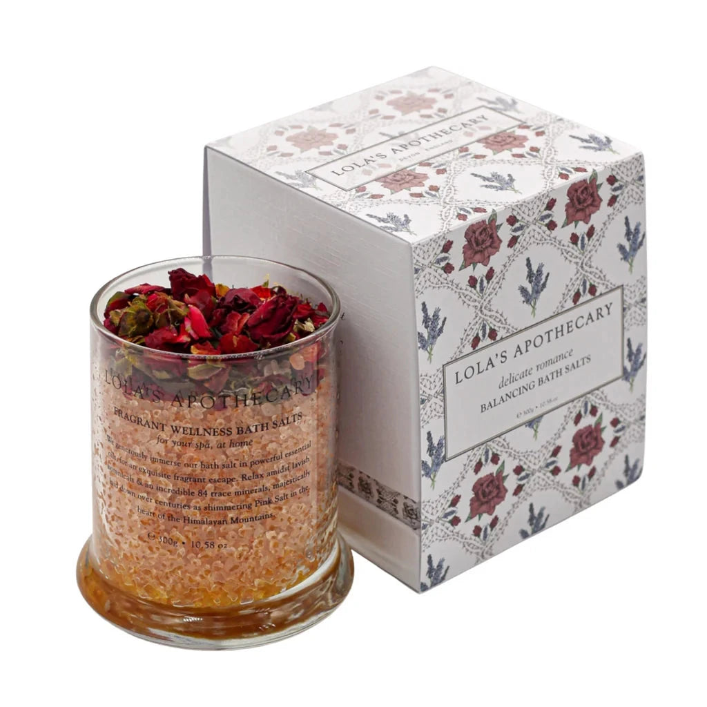 LOLA's APOTHECARY delicate romance bath salts in a transparent jar with red roses on top and the packaging standing next to it 