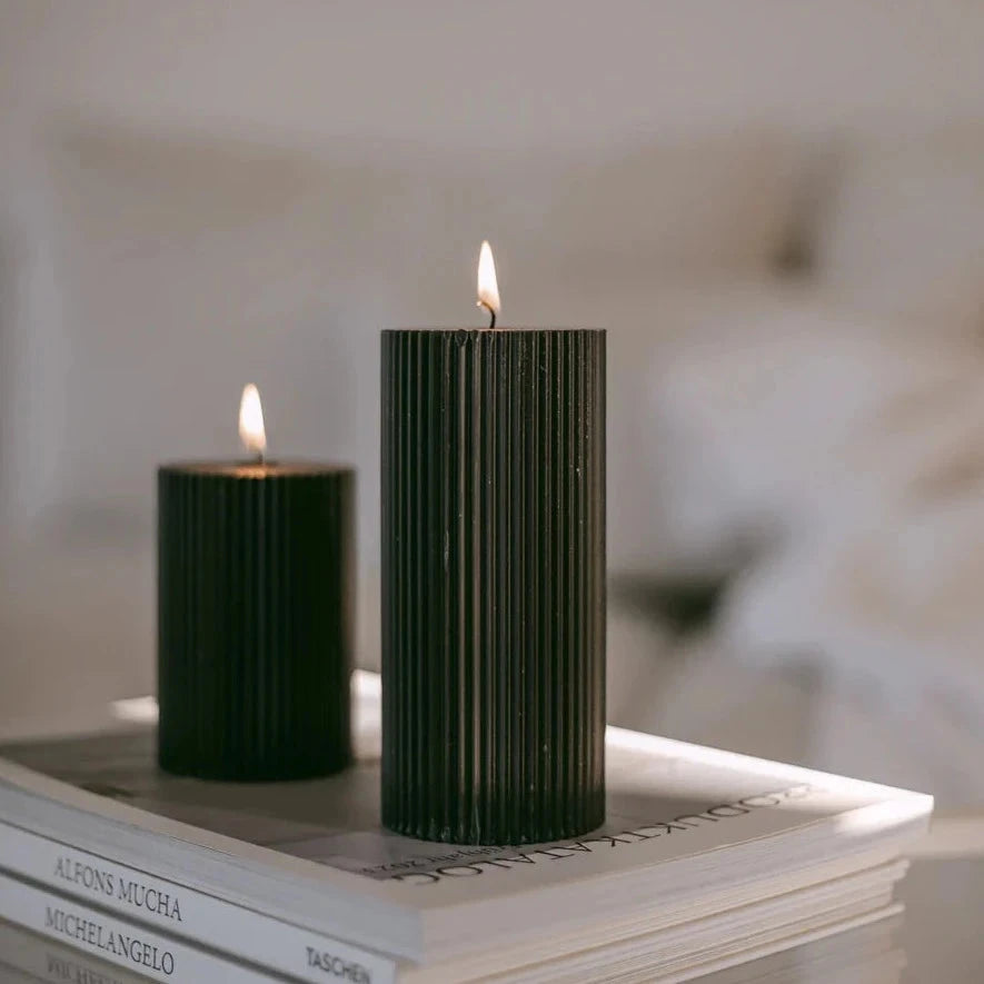 Small and large candle on magazine stack 