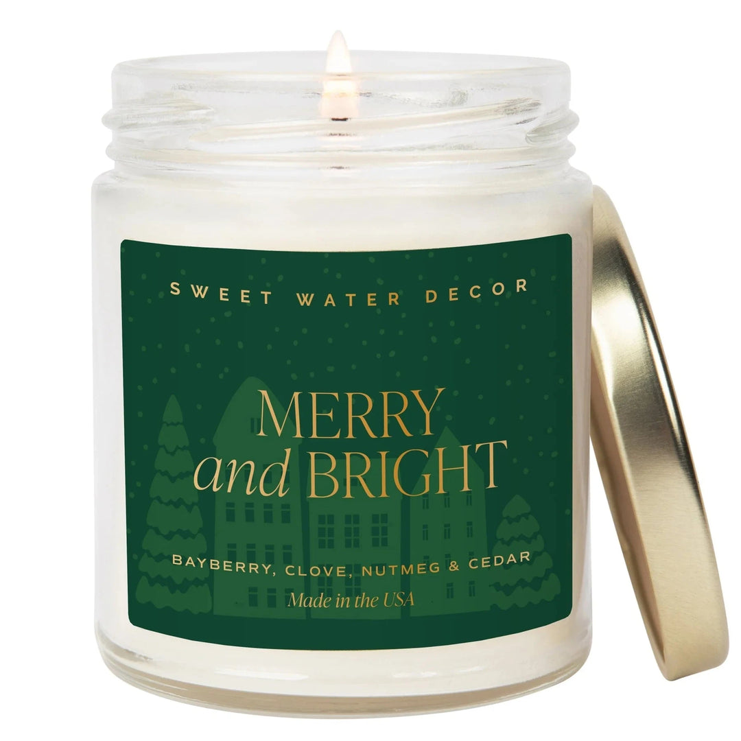 Burning candle MERRY and BRIGHT from Sweet Water Decor, with golden lid next to it.