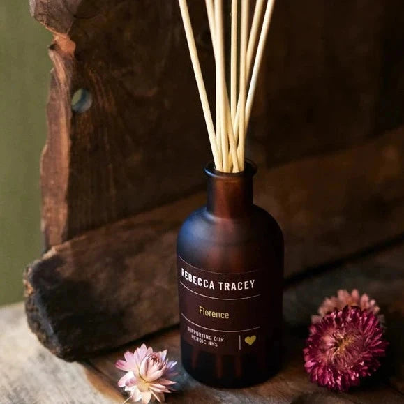 Room fragrance in front of wood with flowers