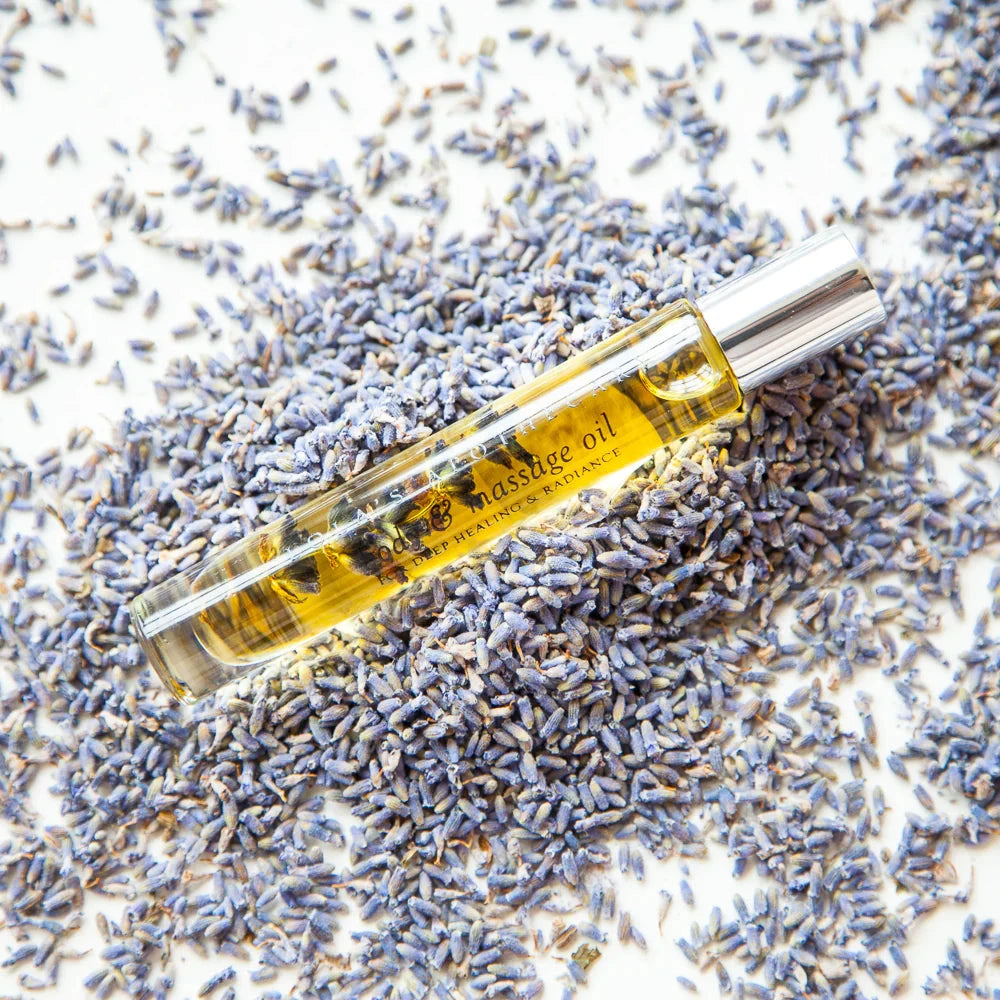 Lola's Apothecary deluxe roll-on Sweet Lollaby bottle lying in lavender flowers North Glow