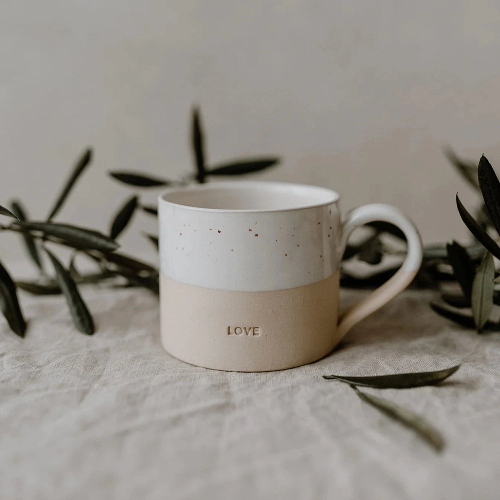Love" teacup stands on a linen cloth