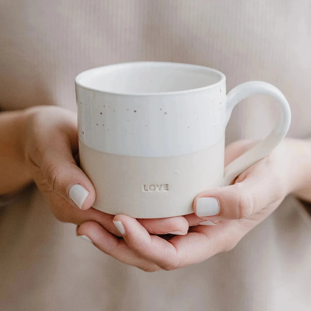 Love" teacup is held by two hands