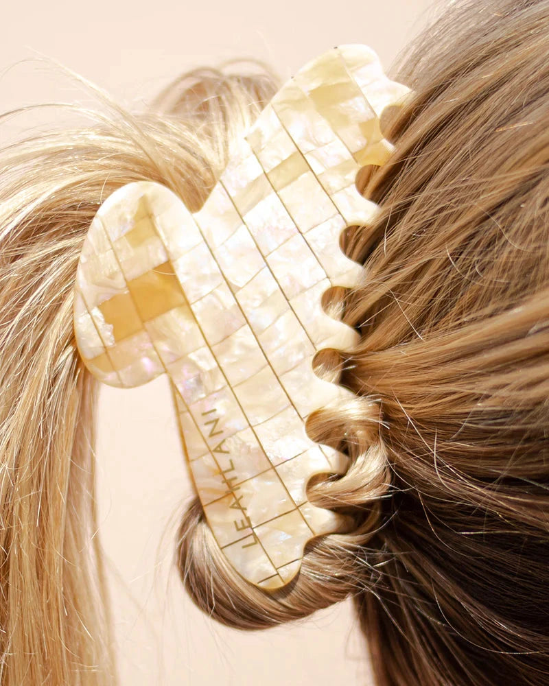 Pearl-colored hair clip from LEAHLANI tucked into the hair. North Glow