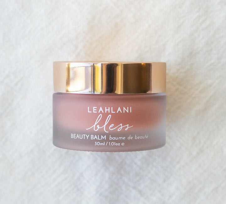 Leahlani Bless Beauty Balm jar with golden lid on light background