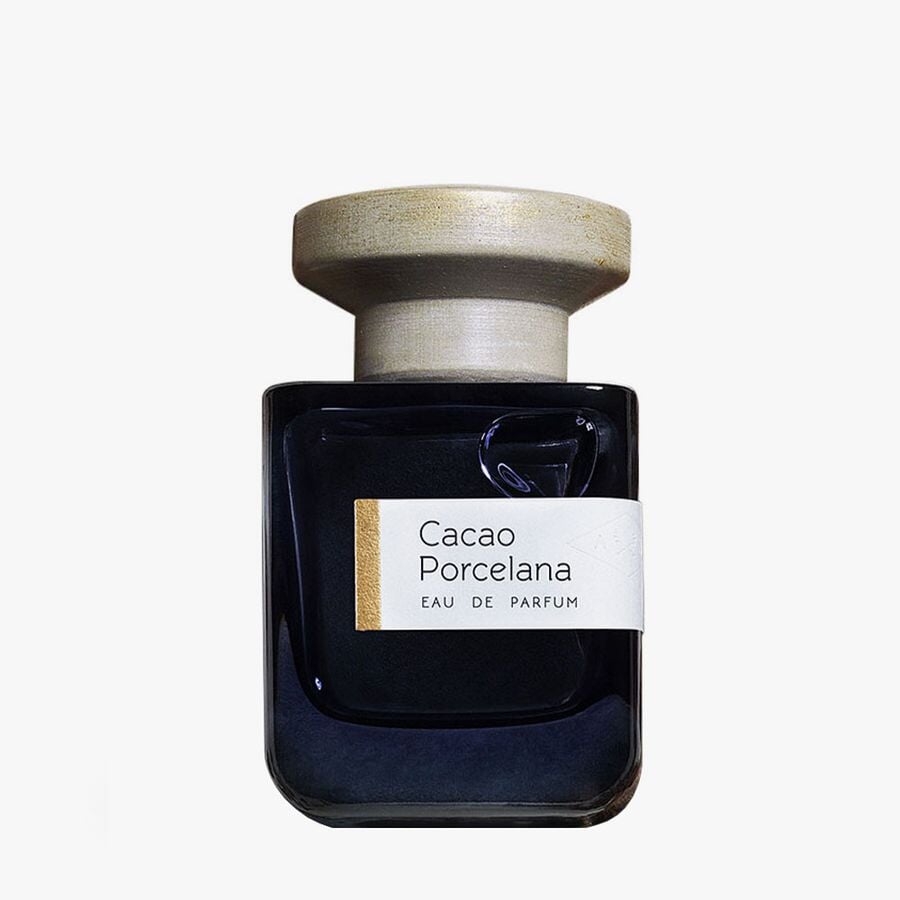 Dark blue glass bottle with gray lid "Cacao Porcelana" by Atelier Materi against a white background. North Glow