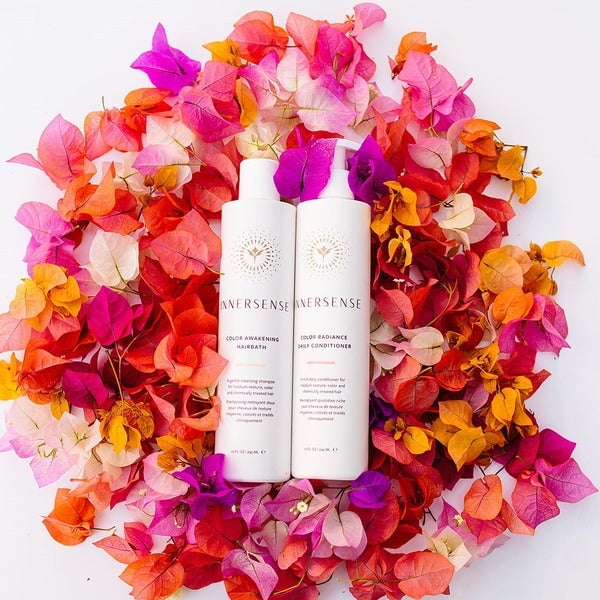 Innersense Color Awakening Hairbath and Color Radiance Daily Conditioner bottles on colorful petals.