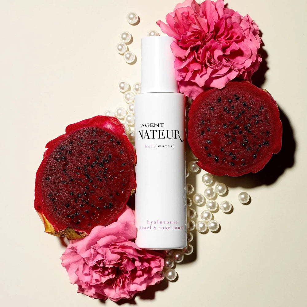 Holi (Water) pearl and rose Essence with pearls, dragon fruit and pink roses on light background