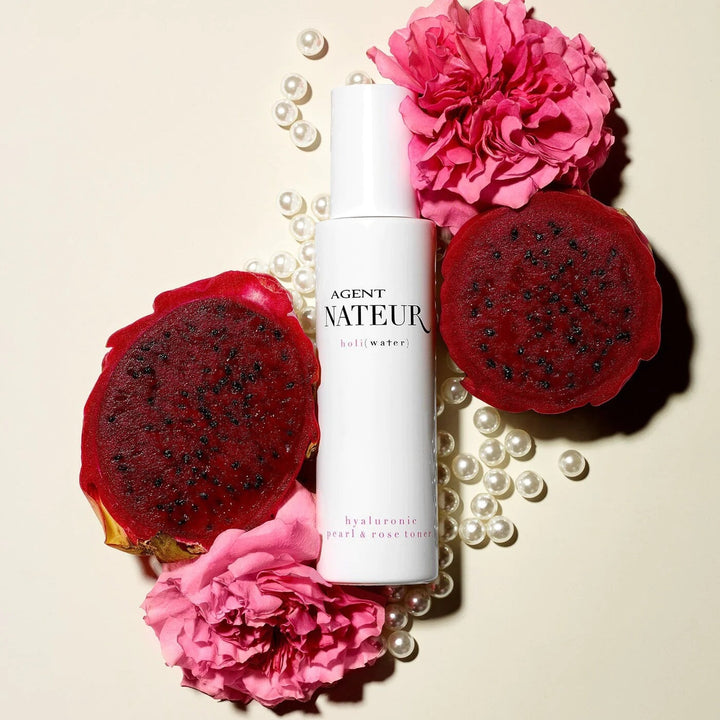 Holi (Water) pearl and rose Essence with pearls, dragon fruit and pink roses on light background