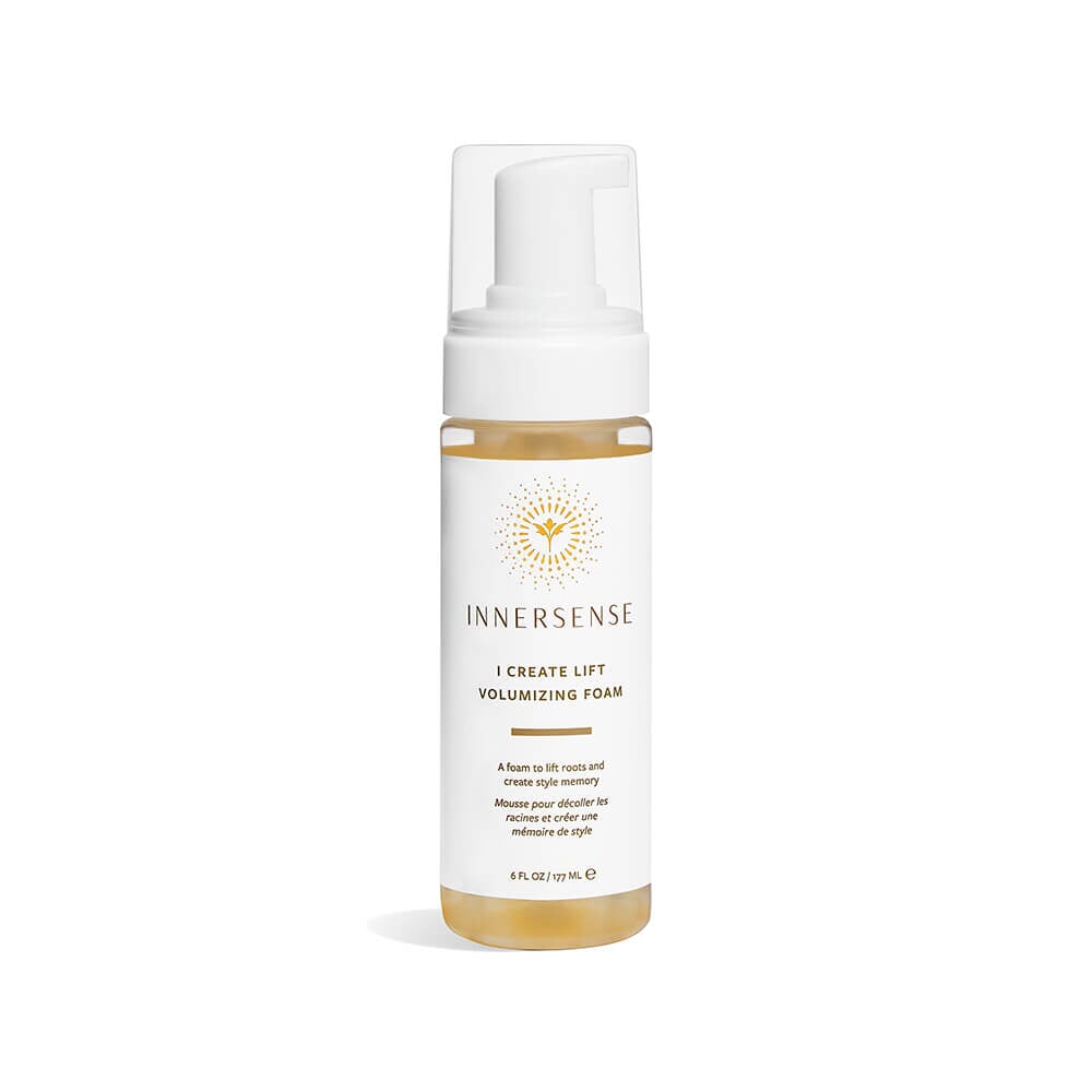 A spray bottle of Innersense I Create Lift Volumizing Foam stands against a white background. North Glow