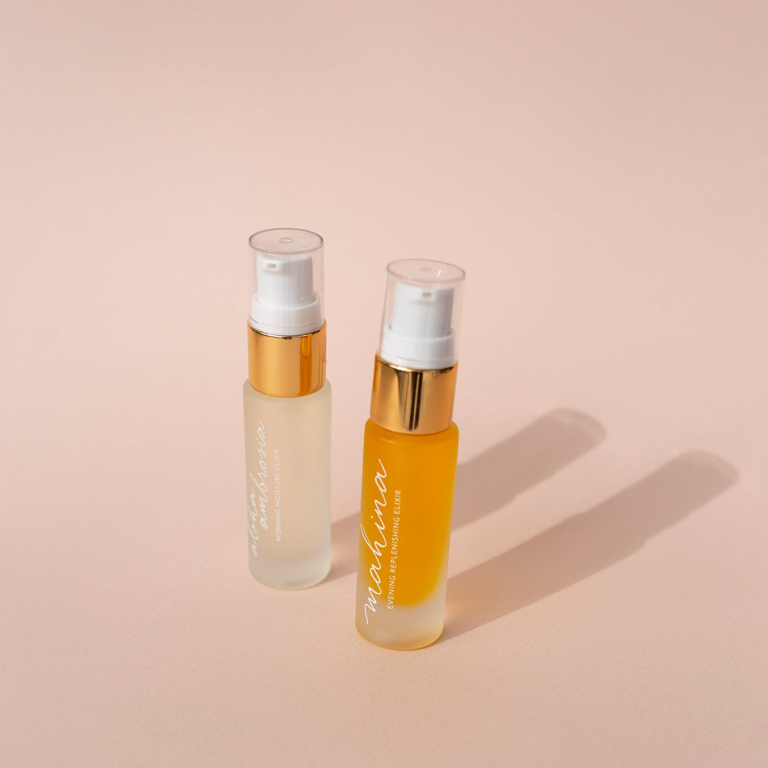 Leahlani small Mahina Evening Elixir bottle and small Aloha Elixir bottle against bright background North Glow
