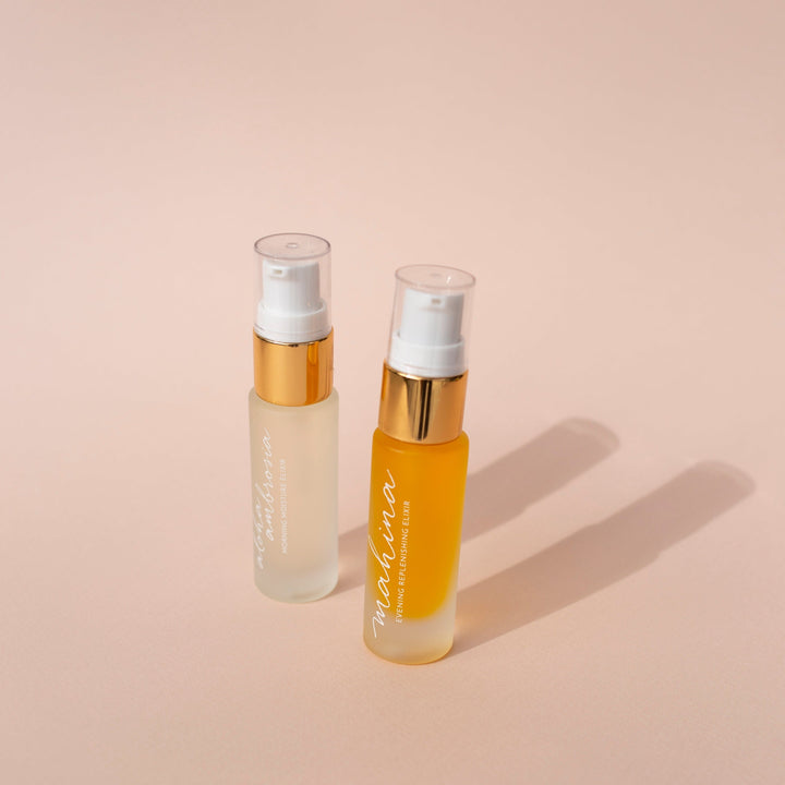 Leahlani small Mahina Evening Elixir bottle and small Aloha Elixir bottle against light background