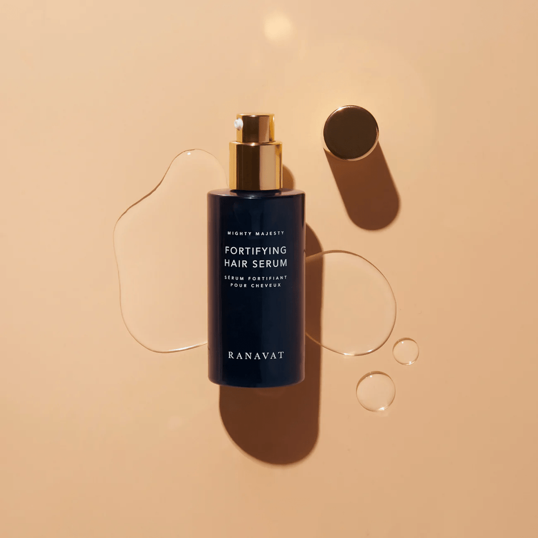 Ranavat Mighty Majesty hair serum bottle with texture on orange background North Glow