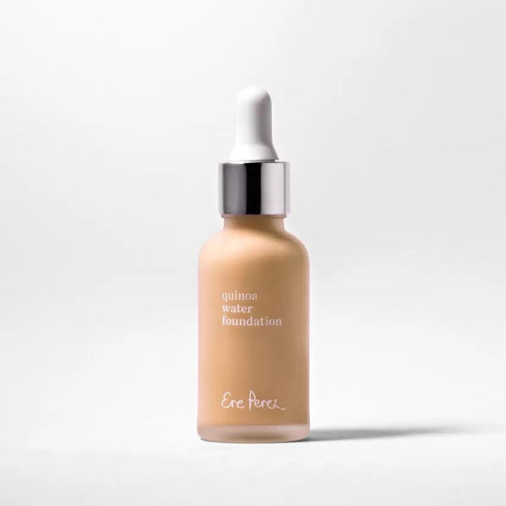 Glass bottle of Ere Perez Quinoa Foundation Dawn against a white background.