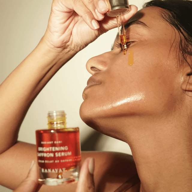 Female model applies Ranavat Brightening Saffron Serum with pipette on face North Glow