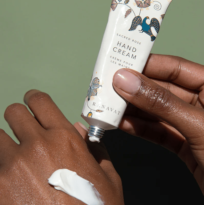 Ranavat Sacred Rose Hand Cream in use against a green background