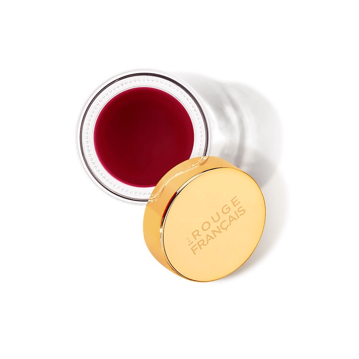 Open jar of Le Baume Teinté No 240 Sigrid Balm on a white background as seen from a bird's eye view.